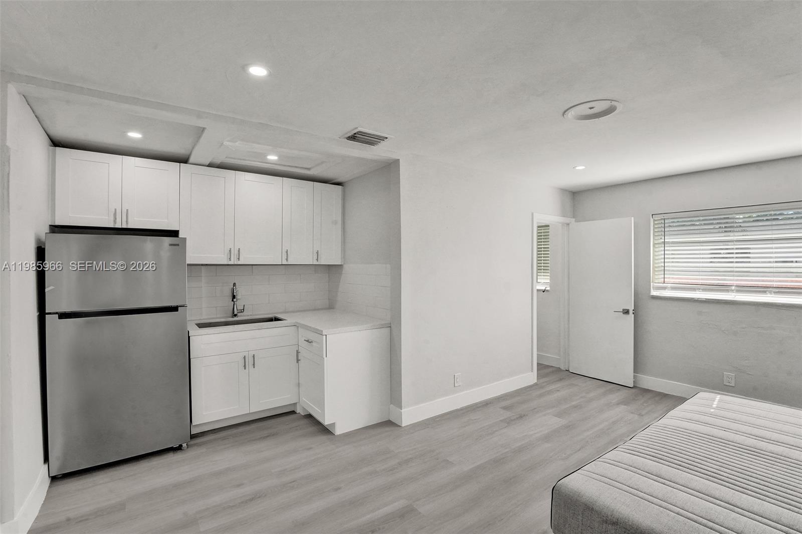 5657 Grant Street, Unit 4 Hollywood, FL 33021 - Photo 5 of 13 a kitchen with white cabinets and white appliances