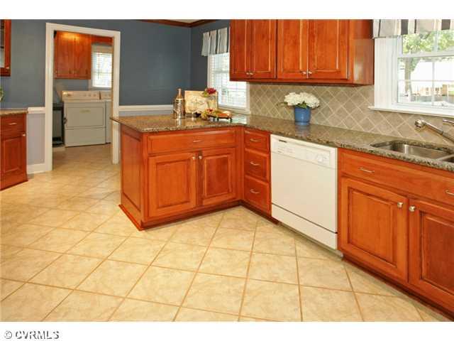 5116 Sylvan Road Richmond, VA 23225 - Photo 5 of 12 Kitchen - The KITCHEN counter is extended, perfect for stools to make a cozy eat-in area. With the laundry room beyond and access to the deck and back yard, space is laid-out for fun and function.