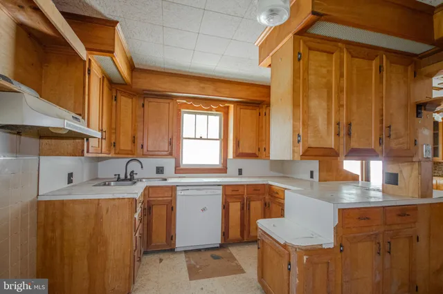 a kitchen with a sink a window and cabinets
