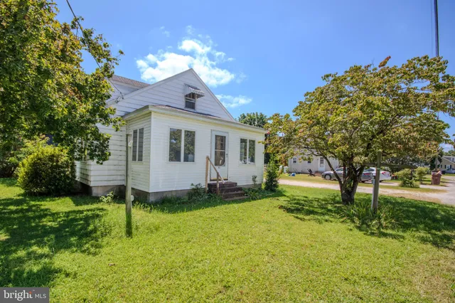 a view of a house with a big yard and large trees