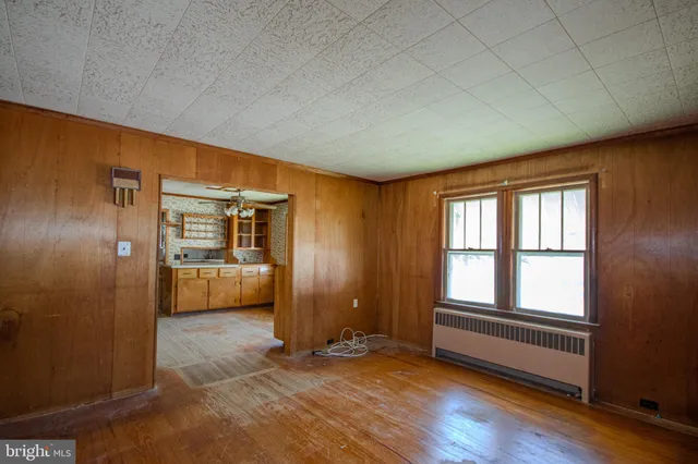 a view of an empty room and a kitchen
