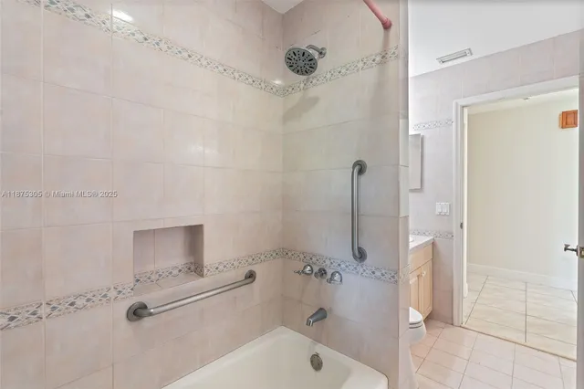 a bathroom with a tub shower sink and mirror
