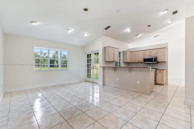 a kitchen with stainless steel appliances granite countertop a refrigerator and a stove top oven