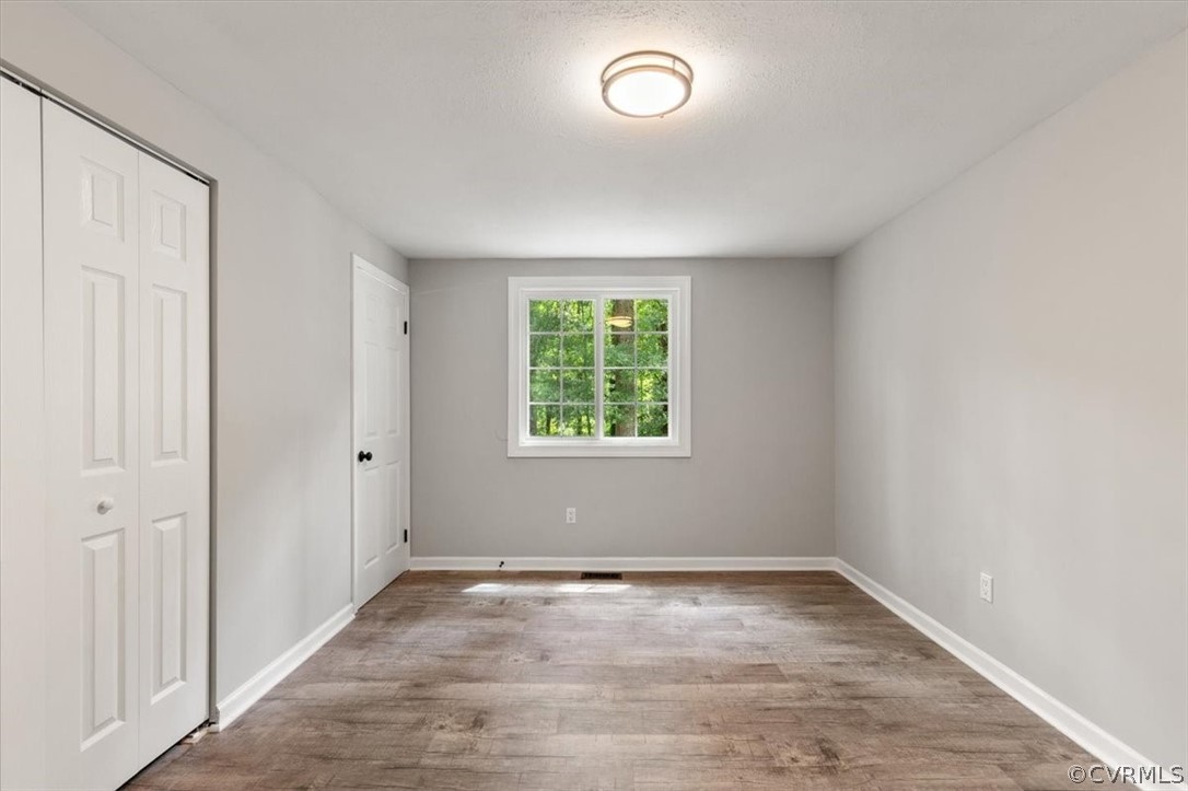 10501 White Rabbit Road Richmond, VA 23235 - Photo 25 of 49 an empty room with wooden floor and windows