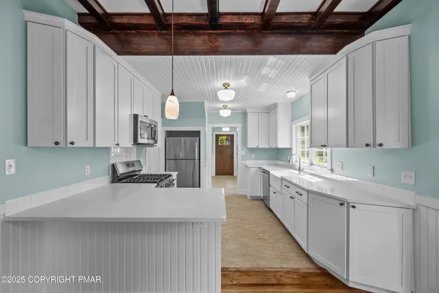 a kitchen with cabinets appliances a sink and a window