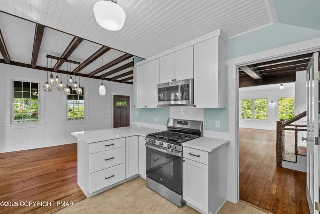 a kitchen that has a lot of cabinets in it and wooden floors