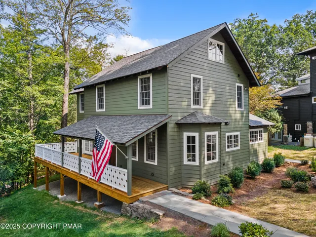 a front view of a house with yard and trees