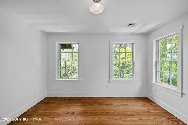 a view of room with window and wooden floor
