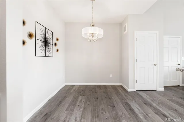 a view of a room with wooden floor chandelier and closet