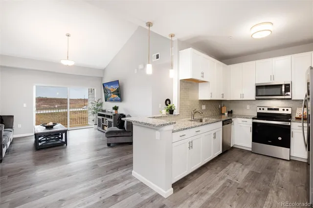 a kitchen with stove a refrigerator and furniture