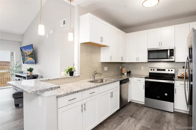 a kitchen with stainless steel appliances granite countertop a sink stove and microwave