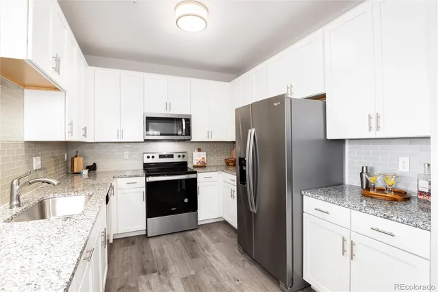 a kitchen with stainless steel appliances granite countertop a refrigerator stove and sink