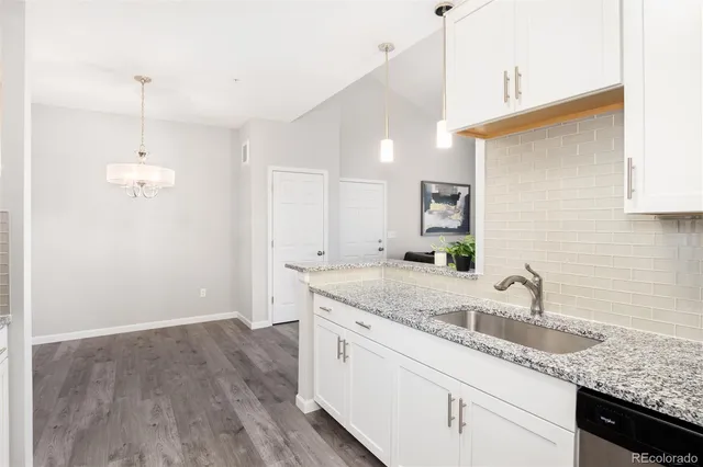a kitchen with a sink cabinets and wooden floor