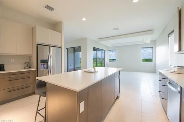 a large kitchen with kitchen island a sink stainless steel appliances and white cabinets