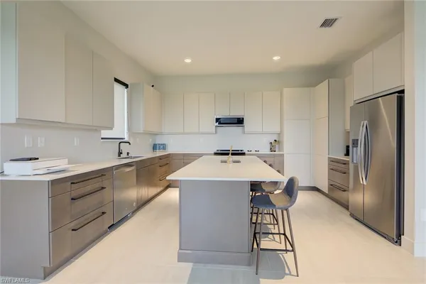 a kitchen with a sink a refrigerator and cabinets