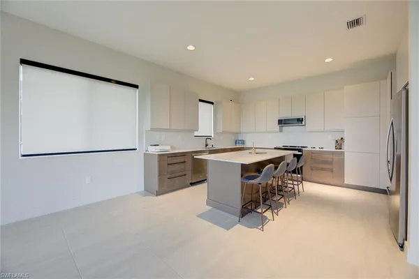a kitchen with a refrigerator a counter top space and appliances