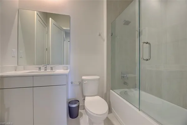 a bathroom with a toilet a sink a mirror and shower