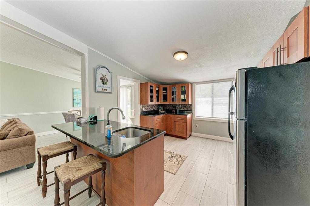 1581 Royal Road Venice, FL 34293 - Photo 14 of 41 a kitchen with granite countertop a refrigerator and a sink