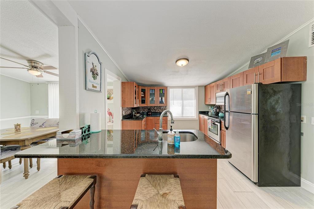 1581 Royal Road Venice, FL 34293 - Photo 15 of 41 a kitchen with stainless steel appliances granite countertop a sink refrigerator and cabinets