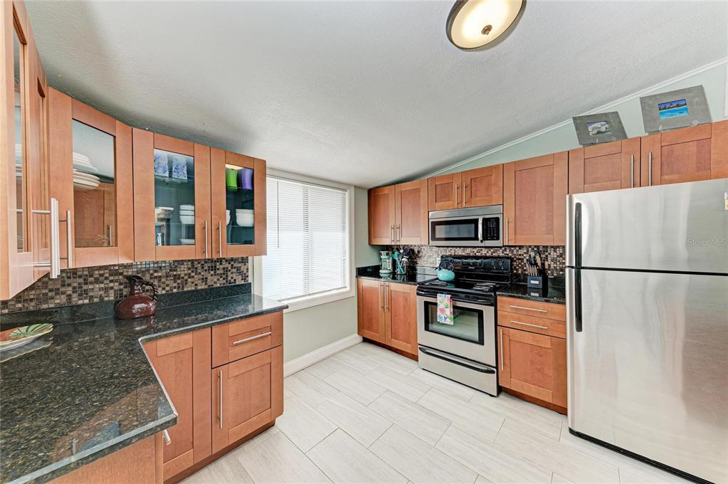 1581 Royal Road Venice, FL 34293 - Photo 17 of 41 a kitchen with stainless steel appliances granite countertop a refrigerator stove top oven and sink