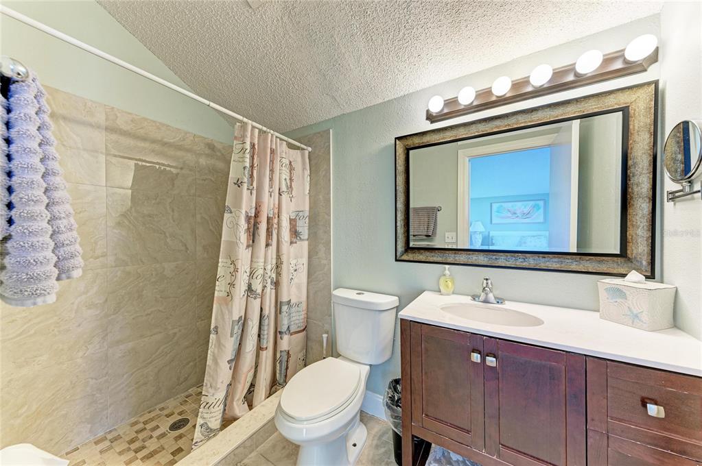 1581 Royal Road Venice, FL 34293 - Photo 26 of 41 a bathroom with a granite countertop toilet a sink and a mirror