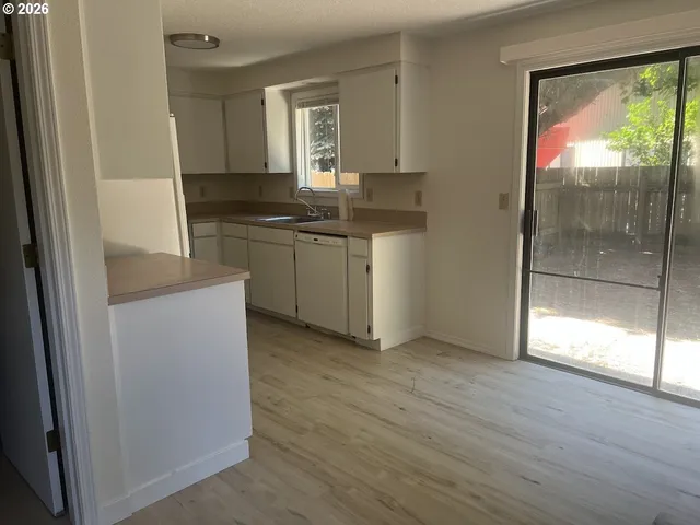 a kitchen with kitchen island white cabinets and refrigerator