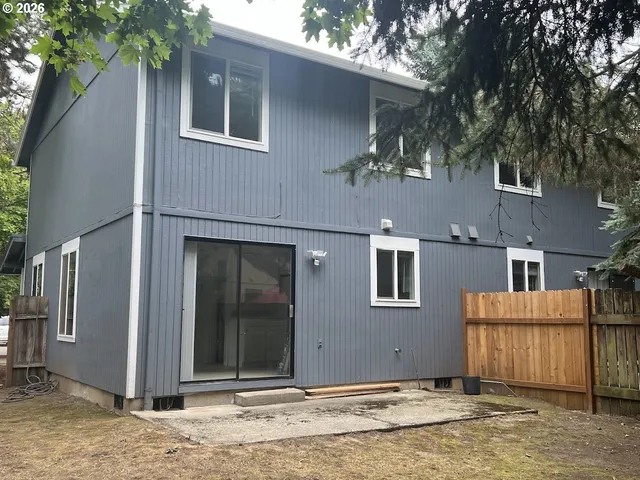 a front view of a house with a tree