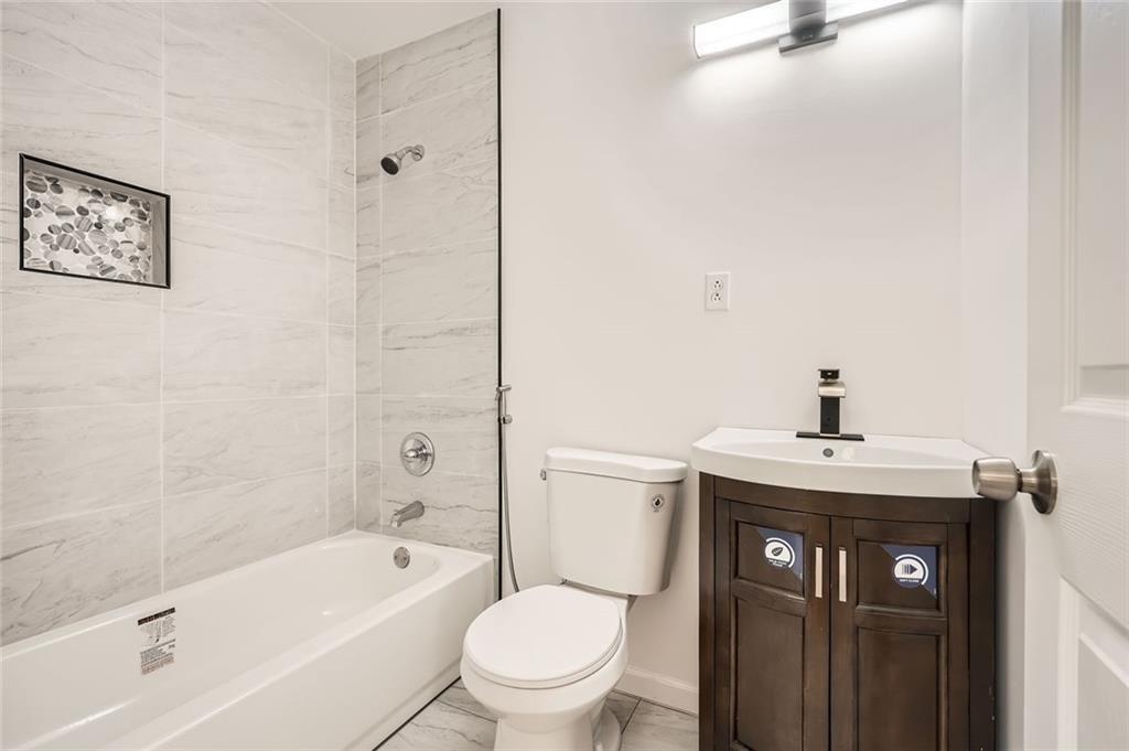 4201 Regal Ridge Road Austell, GA 30106 - Photo 11 of 21 a bathroom with a granite countertop sink a toilet and shower