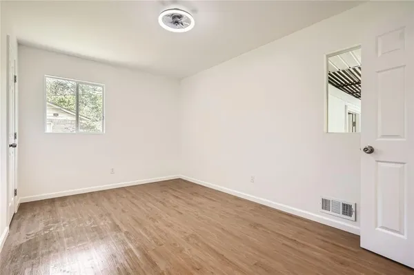 an empty room with wooden floor and window