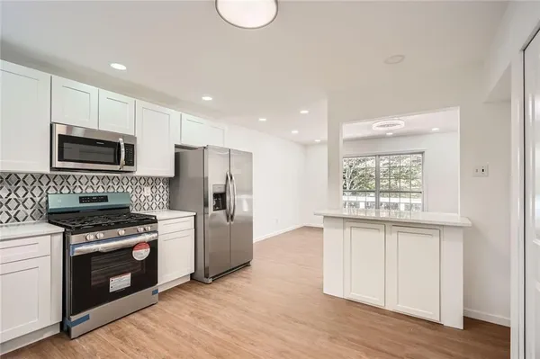 a kitchen with a stove a sink and a microwave