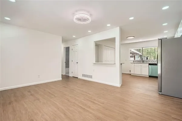 a view of an empty room with a kitchen