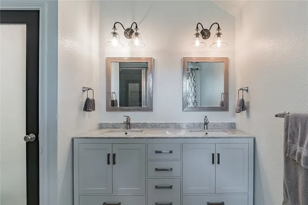 a bathroom with double vanity sinks and a mirror
