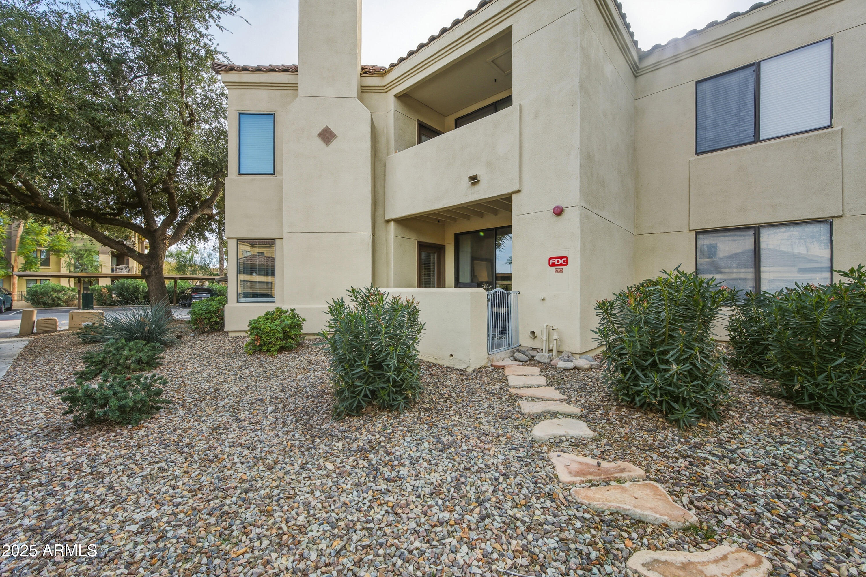 7575 East Indian Bend Road, Unit 1126 Scottsdale, AZ 85250 - Photo 25 of 33 a view of a white house with a small yard and plants