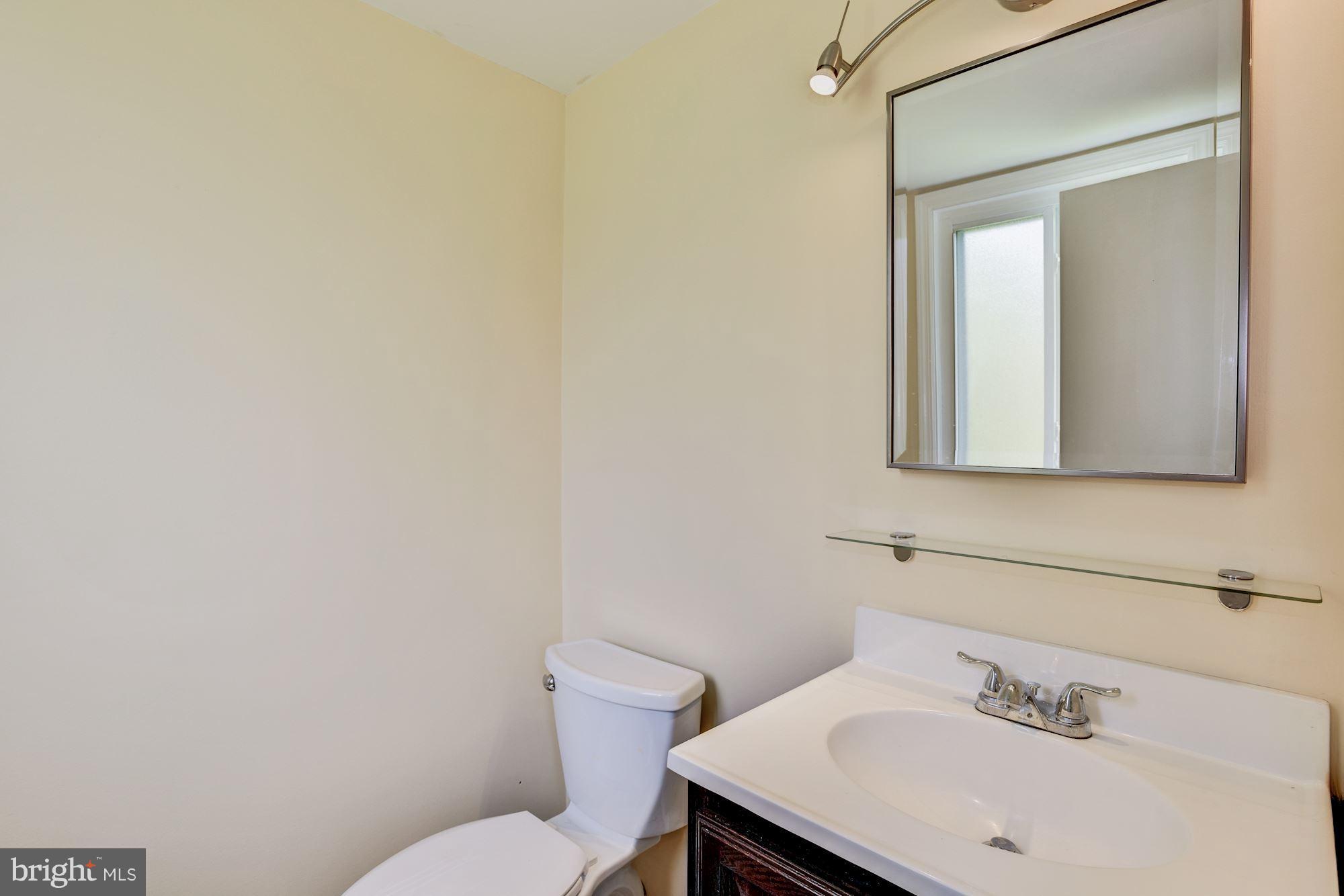 12009 Tarragon Road, Unit F Reisterstown, MD 21136 - Photo 13 of 22 a bathroom with a sink mirror and toilet