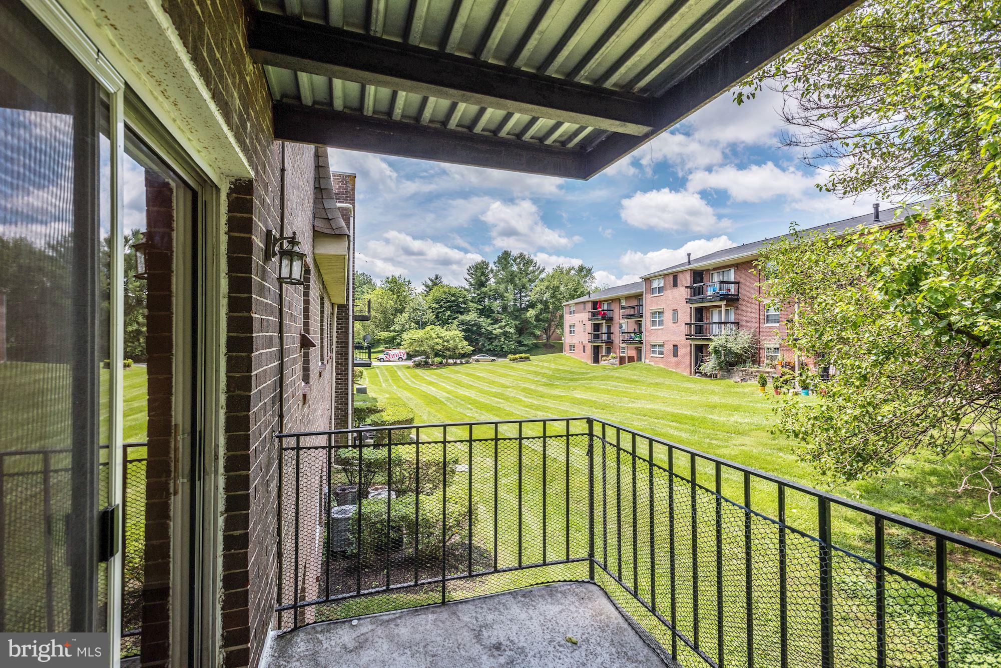 12009 Tarragon Road, Unit F Reisterstown, MD 21136 - Photo 20 of 22 a view of a balcony with a floor to ceiling window and tree