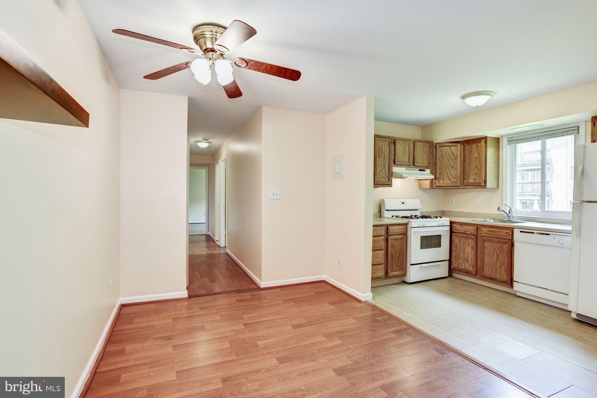 12009 Tarragon Road, Unit F Reisterstown, MD 21136 - Photo 5 of 22 a kitchen with granite countertop a refrigerator and wooden floor