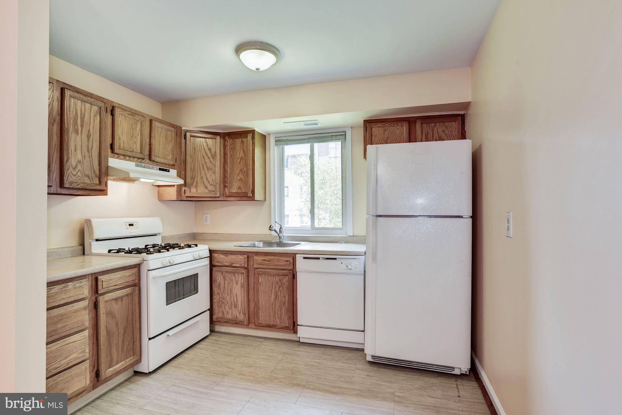 12009 Tarragon Road, Unit F Reisterstown, MD 21136 - Photo 7 of 22 a kitchen with white cabinets and white appliances