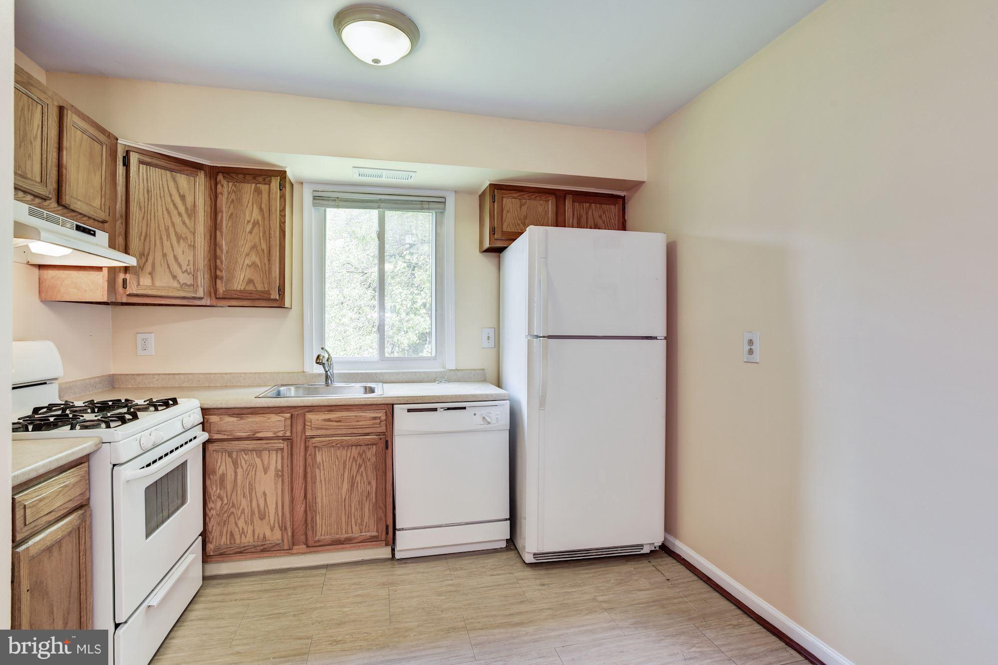 12009 Tarragon Road, Unit F Reisterstown, MD 21136 - Photo 8 of 22 a kitchen with a refrigerator sink stove and cabinets