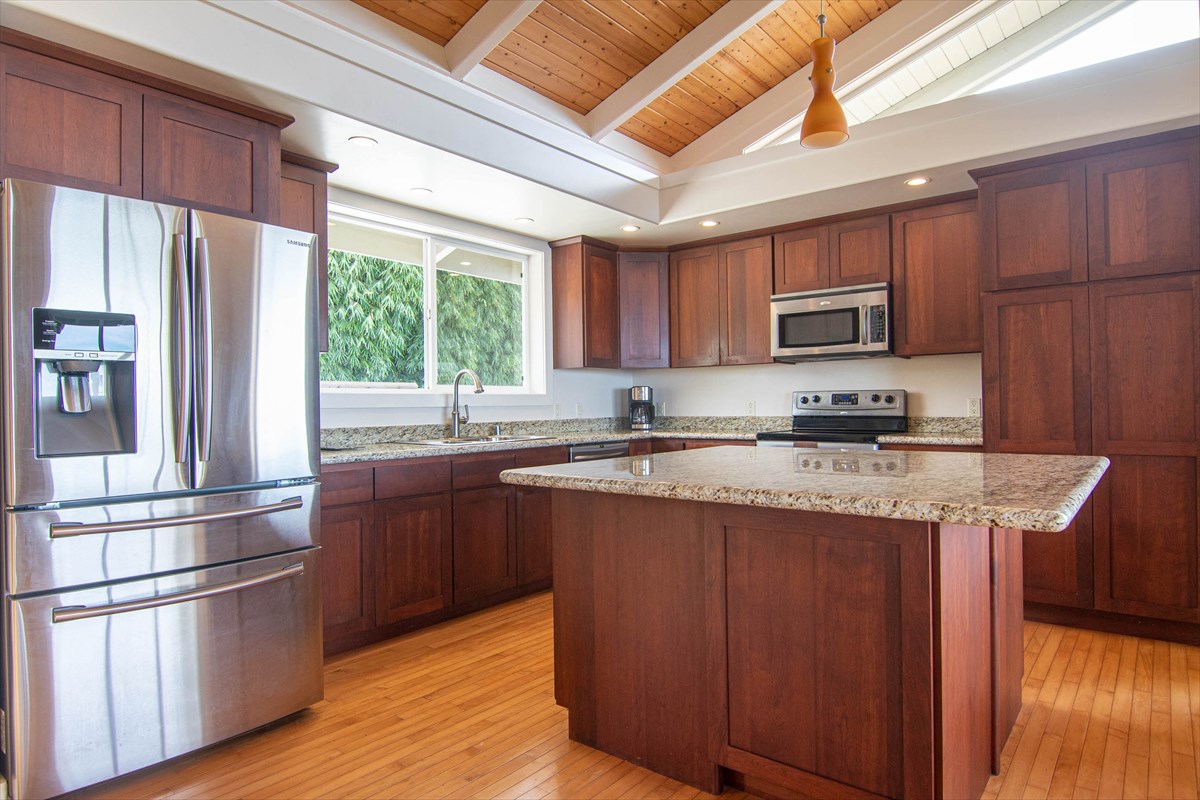 82-1135 Kinue Road Captain Cook, HI 96704 - Photo 3 of 30 a kitchen with stainless steel appliances granite countertop a refrigerator a sink dishwasher a stove and a microwave oven