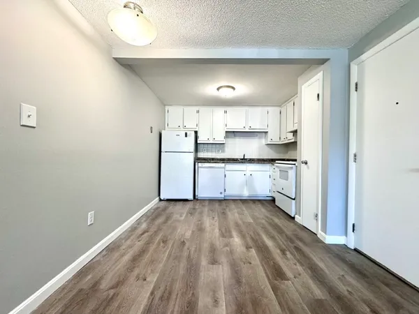 a view of a kitchen with a sink wooden floor and cabinets