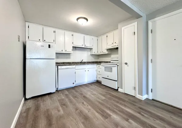 a kitchen with white cabinets stainless steel appliances and a refrigerator