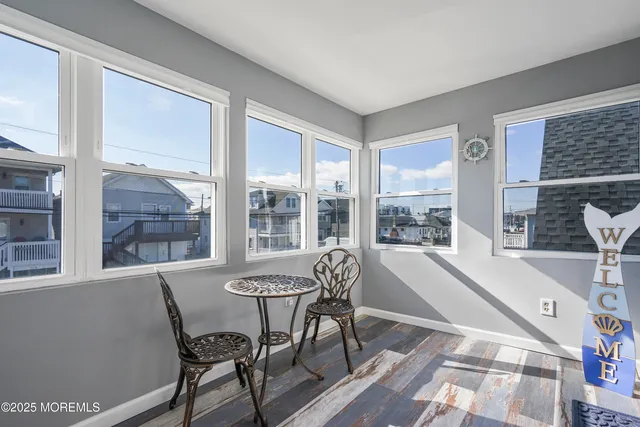a view of a dining room with furniture large windows and wooden floor