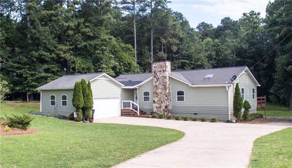 6593 Old Garrett Road Buford, GA 30518 - Photo 1 of 1 a front view of a house with a garden and yard