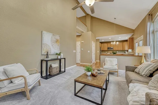 a living room with furniture and a view of kitchen