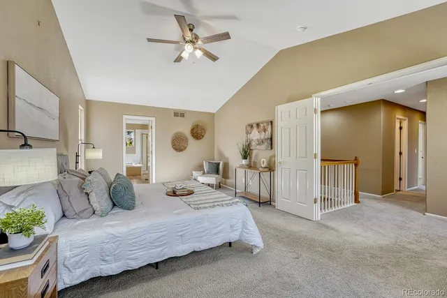 a spacious bedroom with a bed a couch and a chandelier