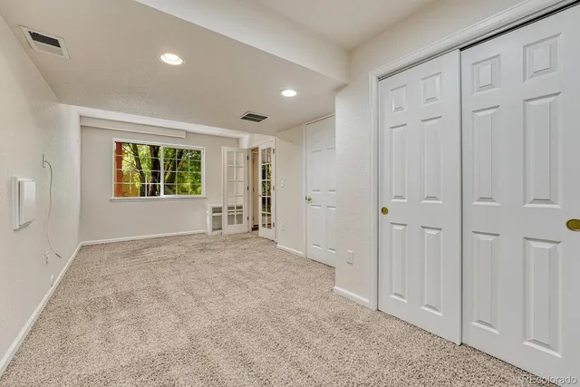 an empty room with windows and closet