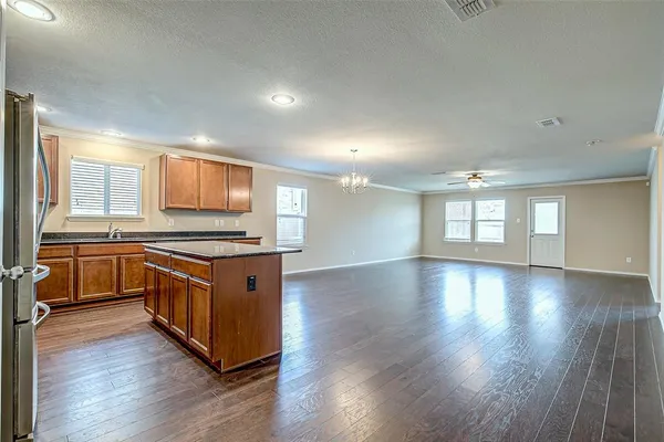 a large kitchen with stainless steel appliances granite countertop a sink and wooden floors