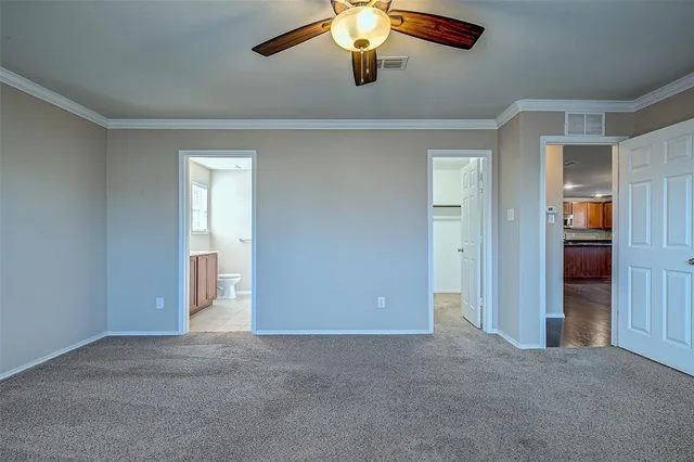 a view of an empty room and chandelier fan
