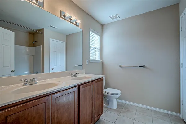 a bathroom with a sink a toilet a mirror and vanity