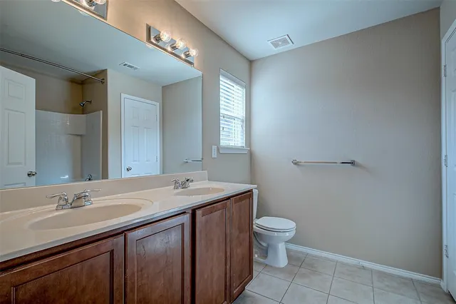 a bathroom with a sink a toilet a mirror and vanity